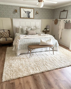 a bed sitting on top of a wooden floor next to a chair and ottoman in a bedroom