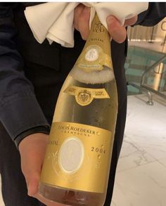 a person holding a bottle of champagne in their hand