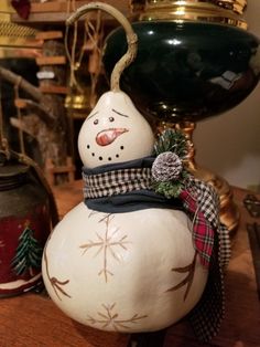 a snowman ornament sitting on top of a wooden table