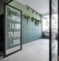 a man sitting on a bench in front of a green wall with words written on it