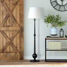 a living room with a lamp, table and clock on the wall