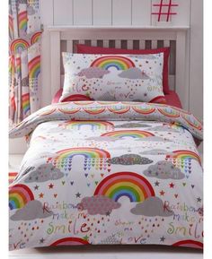 a child's bed with rainbows, clouds and stars on the comforter