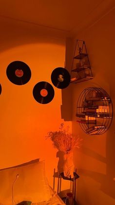 an orange room with record discs hanging from the ceiling and a bed in front of it