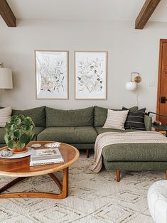 a living room with two couches, a coffee table and pictures on the wall