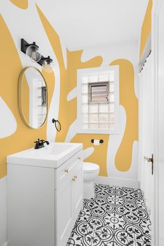 a bathroom with yellow and white decor on the walls