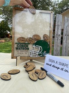 a hand is holding a sign with some corks in front of it and several other things on the table