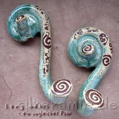 two blue and white swirls on the side of a doorknobl, one with an intricately painted design