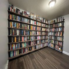 a room filled with lots of books on shelves next to a wall full of books