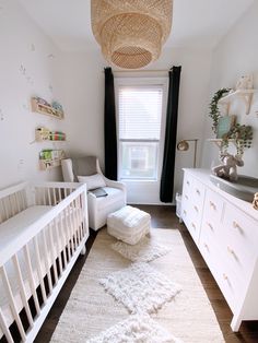 a baby's room with white furniture and decor