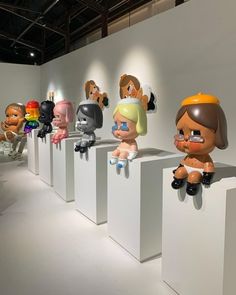 there are many cartoon heads on display in this museum exhibit, and one is wearing an orange helmet