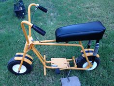 a small yellow tricycle parked in the grass