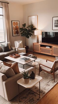 a living room filled with furniture and a flat screen tv on top of a wooden table