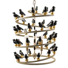 a chandelier with black and gold birds hanging from it's center pole