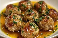 some meatballs with sauce and parsley in a white bowl