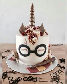 a birthday cake decorated like a unicorn with glasses and horn on top, sitting on a table