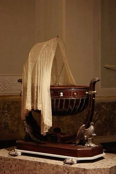 an old fashioned baby carriage on display in a room with marble walls and flooring