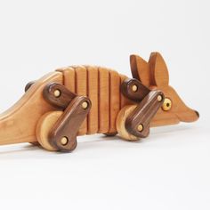 a wooden toy that is shaped like a rat with wheels on it's back