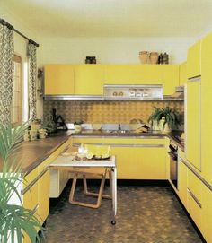 a kitchen with yellow cabinets and tile flooring, including a dining table in the center