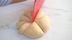 a person is cutting up some food on a marble counter top with a red knife