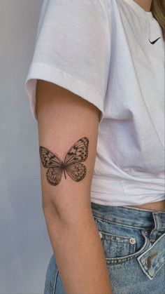 a woman with a butterfly tattoo on her arm