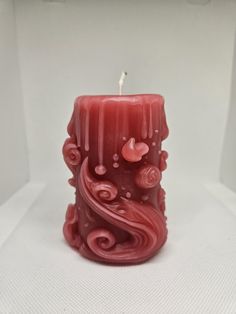 a red candle sitting on top of a white table