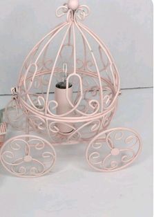 a pink birdcage with two cups in it