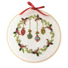 a cross stitch ornament hanging from a red ribbon