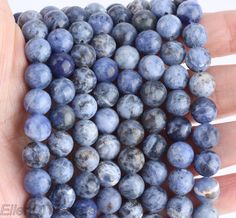 a hand holding several blue beads in it's palm