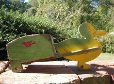 a wooden duck sitting on top of a brick wall