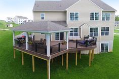 a large house with a deck and patio in the middle of it's yard