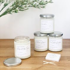 three jars of candles sitting on top of a wooden table