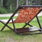 an orange and red chair sitting in the grass