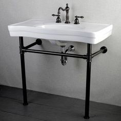 a white sink sitting on top of a metal stand