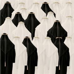 several images of black and white cloaks with gold pins on their backs, all facing different directions