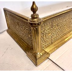 an ornate gold metal box on a white surface