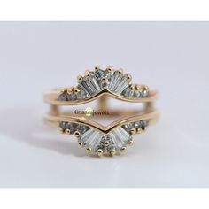 two gold rings with white diamonds on them