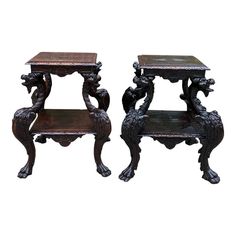 two wooden side tables with carved designs on each end and one sitting on the other