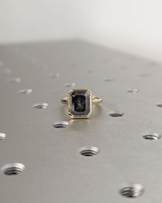 a black diamond ring sitting on top of a metal surface