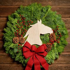 Christmas wreath made of noble fir and cedar with a wooden horse head cutout, 4 pine cones, red berry clusters, and a red brushed linen bow on a dark wood background. Cedar Boughs, Horse Cutout, Horse Wreath, Horse Head Wreath, Horse Wreaths, Gold Hangers, Fresh Wreath, Wood Horse, Wreath Hangers