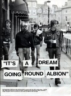 black and white photograph of people walking down the street with signs reading it's a dream going round abon