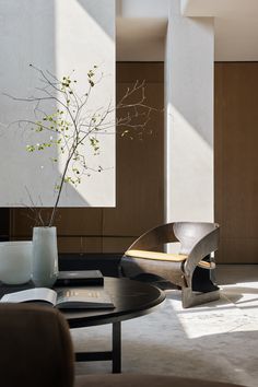 a living room filled with furniture and a vase on top of a wooden coffee table