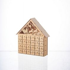 a wooden house with many drawers on the front and side, sitting on a white surface