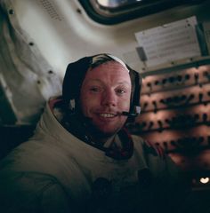 a man wearing an astronaut's helmet is smiling for the camera