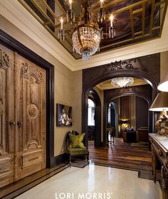 an ornate entry way with chandelier and wooden doors