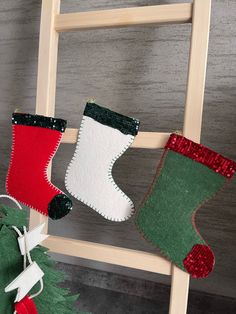 three christmas stockings hanging from a ladder