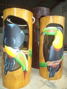 two wooden carved toucans with birds on them