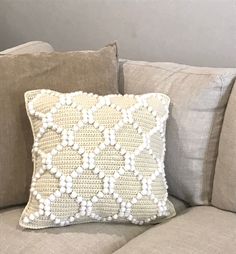 a crocheted pillow sitting on top of a couch