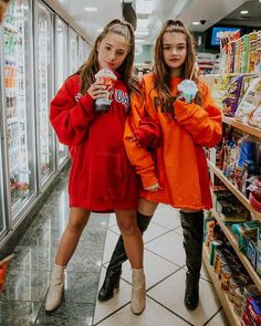 two girls in orange sweatshirts standing next to each other at a grocery store aisle