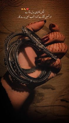 a woman's hand holding several bracelets on top of her arm with arabic writing