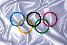 the olympic rings are on top of a white satin fabric, as if it were an official sport